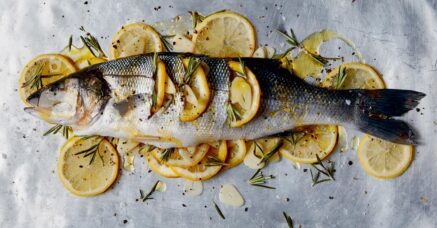 Limonun deniz levreği altında güzel bir sunum ve yeşilliklerle pişmeye hazır.